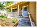 Inviting front porch with stone accents, decorative wreath, and meticulously landscaped garden at 19706 E Bellewood Dr, Centennial, CO 80015