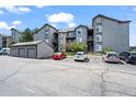 Apartment building exterior features parking, mature trees, and gray siding at 2575 S Syracuse Way # H206, Denver, CO 80231