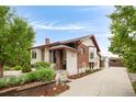 Charming brick and stucco home with well-maintained landscaping, mature trees, and a paved driveway at 3176 Depew St, Wheat Ridge, CO 80214