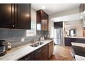Modern kitchen features dark cabinets, granite countertops, stainless steel appliances, and subway tile backsplash at 3176 Depew St, Wheat Ridge, CO 80214
