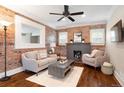 Cozy living room featuring a brick accent wall, fireplace, and lots of natural light at 3176 Depew St, Wheat Ridge, CO 80214