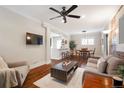 Open-concept living room with breakfast bar, dining area, hardwood floors, and modern lighting at 3176 Depew St, Wheat Ridge, CO 80214