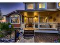 Inviting front porch with decorative door, white railings, and steps leading to a well-lit entrance at 25779 E Jamison Cir, Aurora, CO 80016