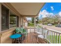 Inviting front porch featuring wooden floors, cushioned bench, chairs and neighborhood views at 6905 Nelson St, Arvada, CO 80004