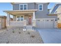 Close up of a charming home with a covered porch, stone accents, and a two car garage at 2690 E 102Nd Pl, Thornton, CO 80229