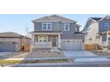 Charming two-story home featuring a covered porch, gray siding, stone accents and a two car garage at 2690 E 102Nd Pl, Thornton, CO 80229