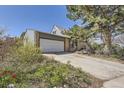 A beautiful exterior view highlighting the home's architecture and spacious driveway, surrounded by colorful foliage at 14742 E Radcliff Pl, Aurora, CO 80015