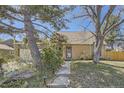 Inviting brick home with large trees and landscaping, offers a serene setting and a charming entryway at 14742 E Radcliff Pl, Aurora, CO 80015