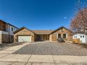 Attractive single-story brick home featuring a spacious two-car garage and a simple rock garden at 1467 S Kenton St, Aurora, CO 80012