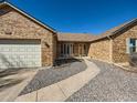 Inviting brick home with a two-car garage and well-maintained landscaping leading to the front door at 1467 S Kenton St, Aurora, CO 80012