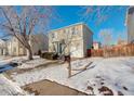 Two-story house with light beige siding, blue door, and attached garage, snow on the ground at 1267 Bluejay Ave, Brighton, CO 80601