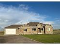 Ranch style home with stone accents and a two-car garage at 45425 Wolf Creek Dr, Bennett, CO 80102