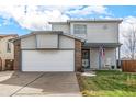 Two-story house with a two-car garage, light siding, and brick accents at 6119 Zenobia Ct, Arvada, CO 80003