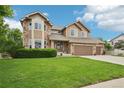 Charming two-story home with manicured lawn, three-car garage, and inviting stone accents at 9158 Forest St, Firestone, CO 80504