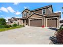 Charming exterior of home featuring a three-car garage, manicured lawn and inviting covered porch at 3008 Echo Park Dr, Castle Rock, CO 80104