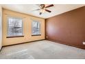 Comfortable bedroom with neutral carpet, two windows, and a ceiling fan, creating a cozy and restful ambiance at 1745 Shallot Cir, Lafayette, CO 80026