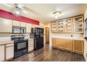 Well-equipped kitchen with modern black appliances, laminate wood flooring, and ample cabinet space, functional for culinary pursuits at 1745 Shallot Cir, Lafayette, CO 80026