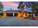 Spacious three-car garage and driveway with beautiful wood doors on an inviting stucco home at 17995 Minglewood Trl, Monument, CO 80132