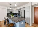 Charming kitchen with granite countertops, stainless steel appliances, and light gray cabinetry at 601 W 11Th Ave # 910, Denver, CO 80204