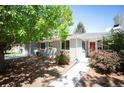 Charming single-story home with mature trees and landscaping leading to a welcoming red front door at 5523 E Utah Pl, Denver, CO 80222