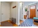 Welcoming entryway with wood flooring, coat rack, and view of the staircase at 3227 Quivas St # 1, Denver, CO 80211