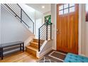 Bright foyer featuring hardwood floors, modern railing staircase and stained wood front door at 3227 Quivas St # 1, Denver, CO 80211
