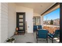 Inviting front porch with modern furniture and a stylish front door at 17826 E 107Th Way, Commerce City, CO 80022