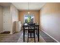 Dining room with hardwood floors, modern light fixture, and a view into the front yard at 1772 Taos St, Brighton, CO 80603
