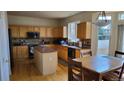 Bright kitchen featuring wooden cabinets, a center island, and modern appliances at 8024 W 95Th Way, Broomfield, CO 80021
