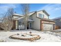 Inviting home exterior showcasing a well-maintained front yard with a quaint brick-bordered flower bed under a clear blue sky at 14558 Vine St, Thornton, CO 80602