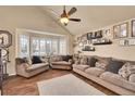 Comfortable living room featuring a large window, hardwood floors, and neutral-toned furniture at 14558 Vine St, Thornton, CO 80602