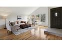 Cozy living room featuring hardwood floors, a vaulted ceiling, and large windows at 8174 Field Cir, Arvada, CO 80005