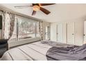 Spacious bedroom with a ceiling fan, large window, and access to the outdoor balcony at 11531 S Deer Creek Rd, Littleton, CO 80127