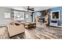 Cozy living room featuring hardwood floors, stone fireplace, and scenic window views at 11531 S Deer Creek Rd, Littleton, CO 80127