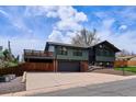 A spacious driveway complements this home featuring a unique architectural design and a welcoming front facade at 13588 W Exposition Dr, Lakewood, CO 80228