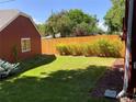 Lush green backyard featuring a privacy fence, well-manicured lawn, and mature trees at 1273 S Jackson St, Denver, CO 80210