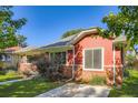 Exterior view of a brick home with fresh paint, a driveway, and manicured landscaping at 1273 S Jackson St, Denver, CO 80210