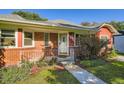 Up close view of the charming brick home with landscaped yard and a walkway leading to the front door at 1273 S Jackson St, Denver, CO 80210