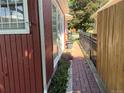 A brick path lined with flowers separates the house and fence, leading towards the backyard at 1273 S Jackson St, Denver, CO 80210