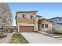 Two-story home with a brown garage door, light-yellow siding, and landscaped front yard at 10808 Salida St, Commerce City, CO 80022