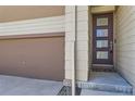 Close up of a modern front door, garage door and neutral siding of a charming home at 10808 Salida St, Commerce City, CO 80022