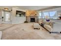 Spacious living room with a stone fireplace, wood paneling, large windows, and comfortable seating at 18045 Sunburst Dr, Monument, CO 80132