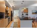 Spacious kitchen with stainless steel appliances, black countertops, and a breakfast bar at 2240 N Clay St # 501, Denver, CO 80211