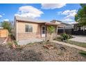 Charming home with a well-maintained front yard, walkway, and covered porch with a metal awning and decorative posts at 1910 S King St, Denver, CO 80219