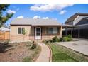 Charming home with a well-maintained front yard, walkway, and covered porch with a metal awning and decorative posts at 1910 S King St, Denver, CO 80219