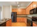 A well-lit kitchen features wooden cabinets, stainless steel appliances, and ample counter space at 8467 Canyon Rim Cir # 302, Englewood, CO 80112