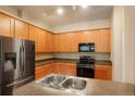 A modern kitchen with stainless steel appliances, light wood cabinetry, and laminate countertops at 8467 Canyon Rim Cir # 302, Englewood, CO 80112
