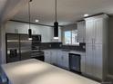 Bright kitchen featuring white cabinets, quartz countertops, stainless steel appliances, and modern pendant lighting at 8954 N Carr Cir, Broomfield, CO 80021