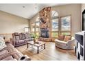The living room has a stone fireplace and vaulted ceilings, with many windows framing the outside views at 15125 Spring Valley Rd, Larkspur, CO 80118