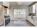Modern kitchen with stainless steel appliances, stone backsplash, white cabinetry, and tile flooring at 4818 Bryant St, Denver, CO 80221